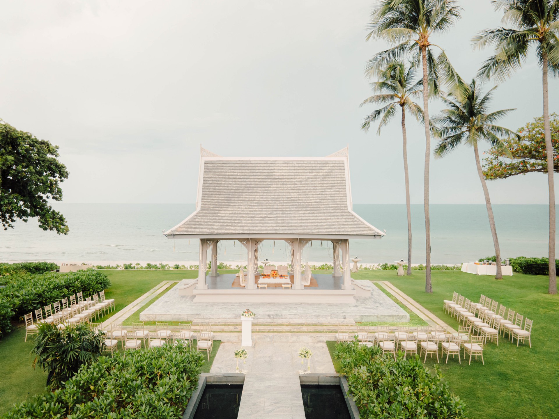 The ocean-view sala pavilion on the lawn at Centara Reserve Samui, set with chairs for a wedding ceremony above Chaweng Beach