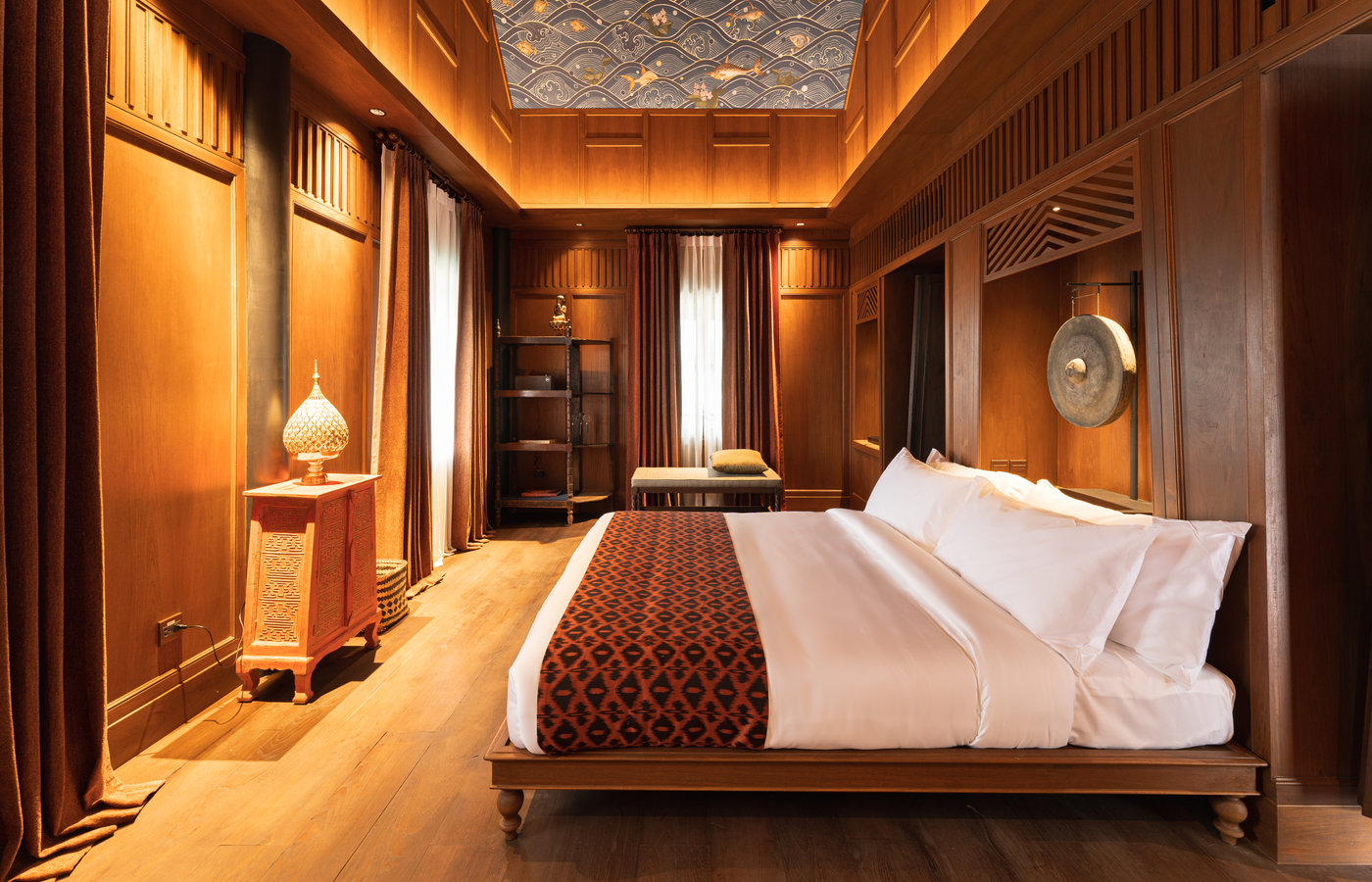 A teak-panelled suite at Siri Sala with shuttered windows